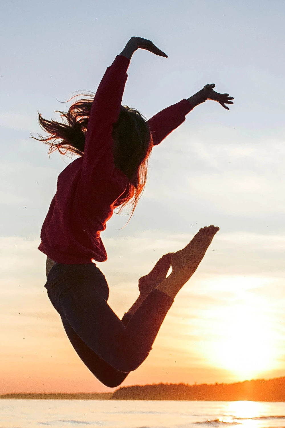 Frau im Sprung bei Sonnenuntergang – Symbolbild für Bewegung und Aktivität